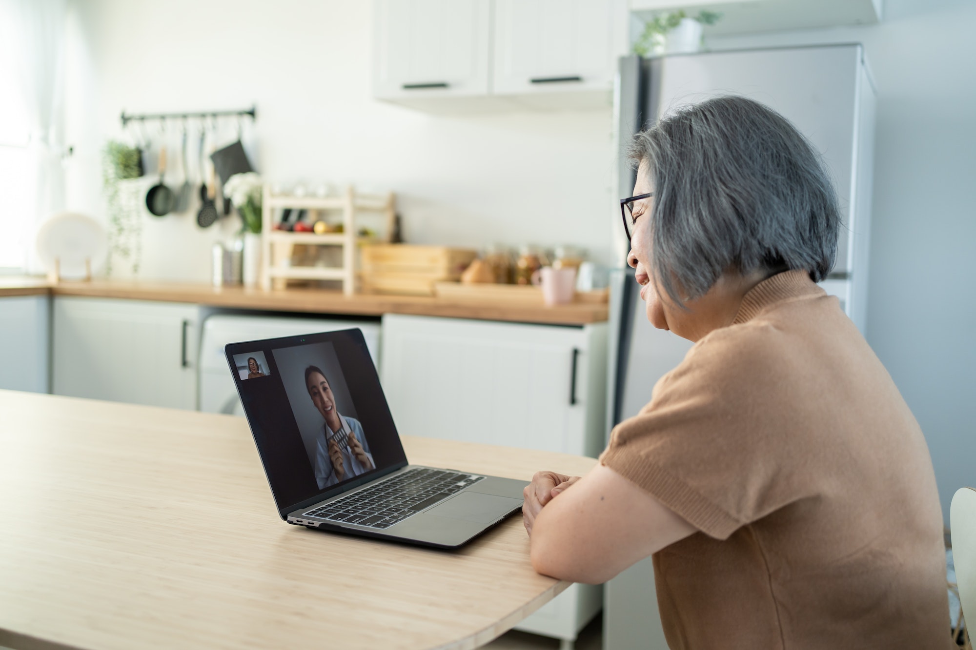 Asian senior older woman telehealth call