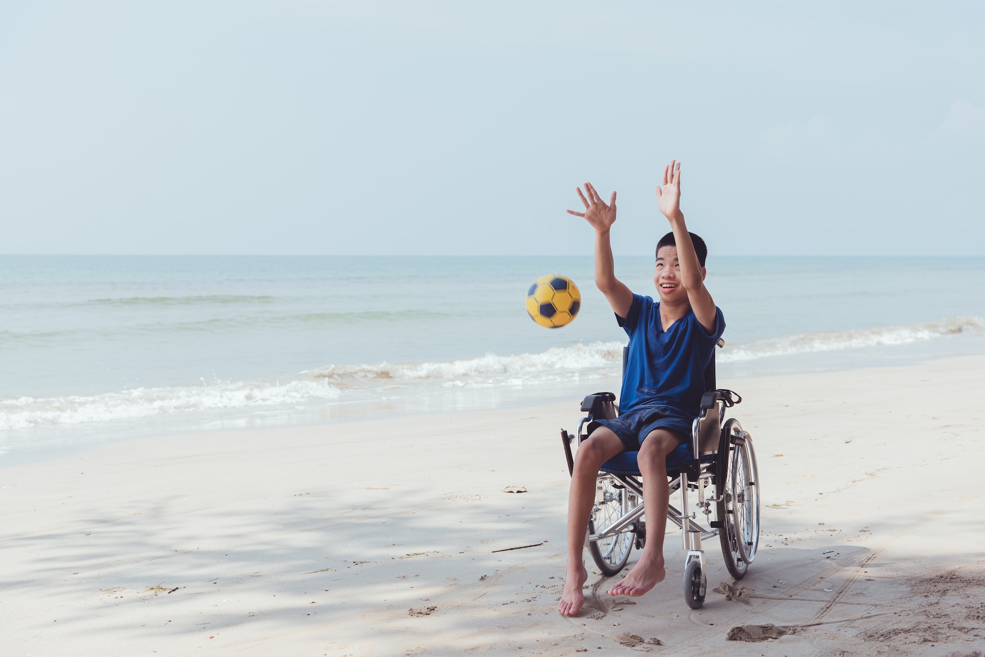 Young man with disability playing on the beach